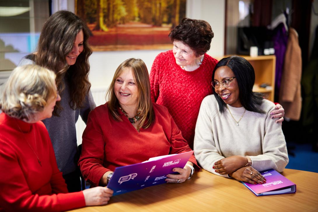 Group of people gathered together looking at UCB material